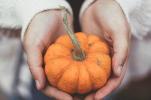 girl holding small pumpkin